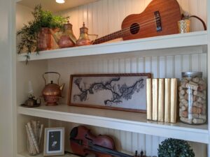 Book shelf that contains staging decor items such as tea pots books and instruments.