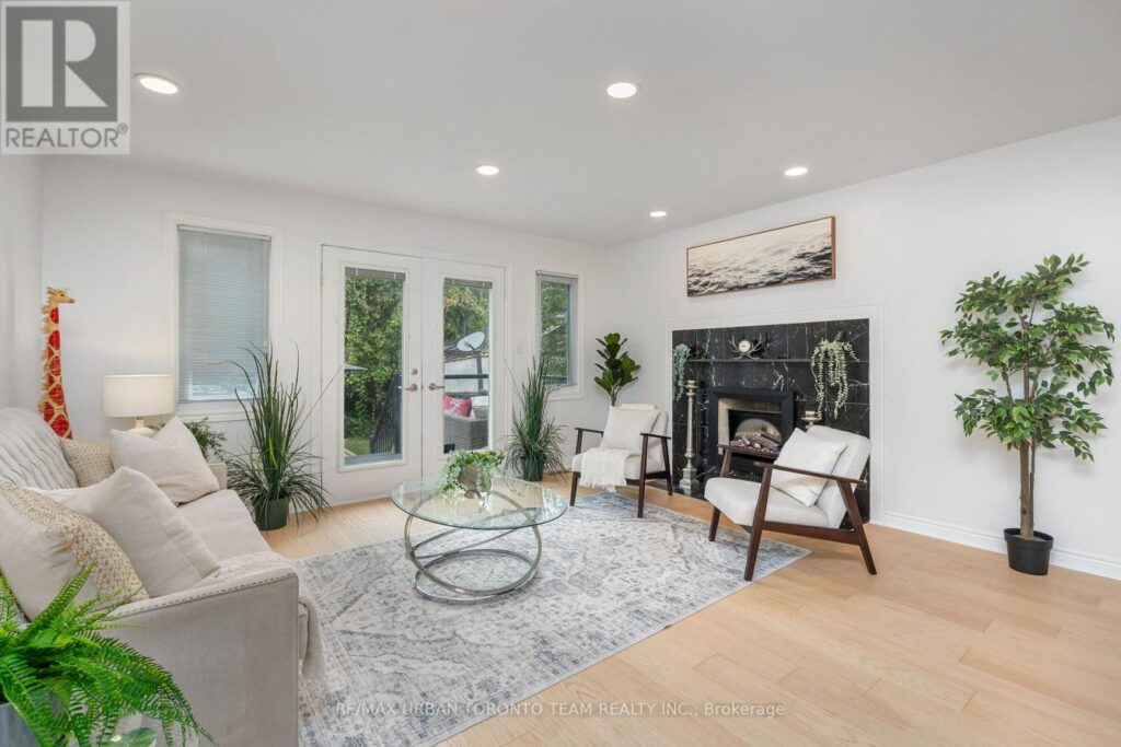 Formal living room staged to highlight walkout doors, fireplace, and open-concept design.